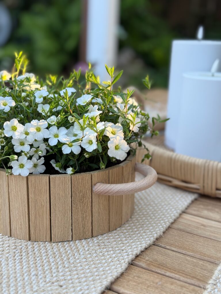 Selbst gebastelte Blumenschale aus Holzklötzchen mit weißen Blüten und Holzgriffen