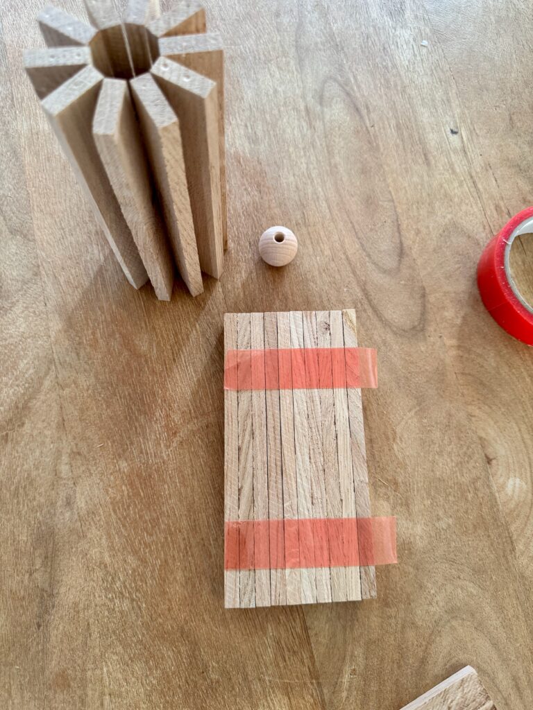 10 Holzklötzchen verbunden mit Klebeband zum Basteln eine Kerzenhalters