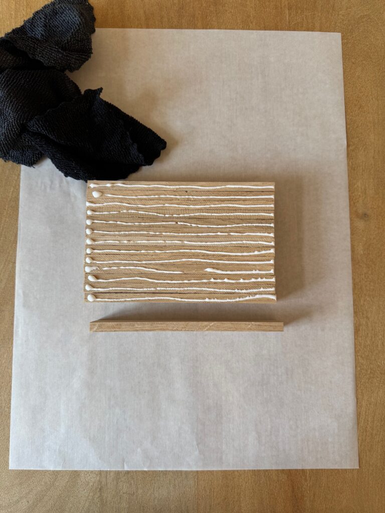 Holzklötzchen mit Mikrofasertuch und Holzleim