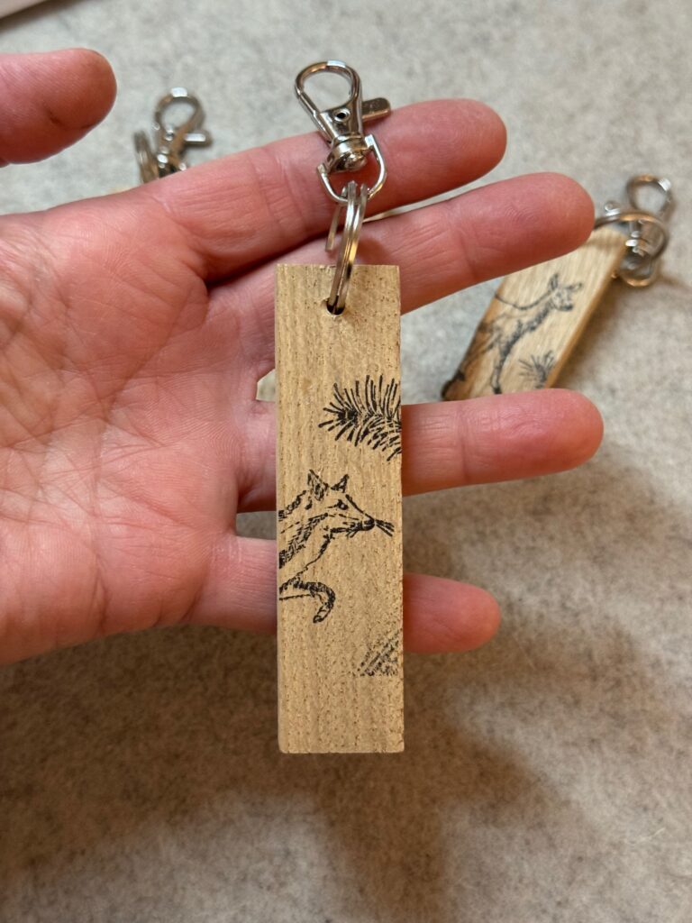 Schlüsselanhänger aus einem Holzklötzchen schwarz bestempelt mit Tiermotiv